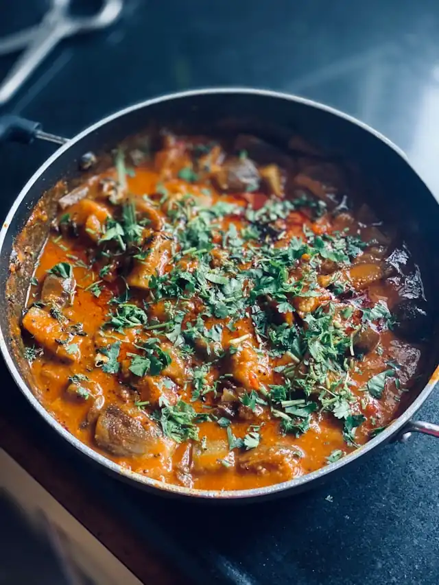 Ragoût d’aubergine maison avec noix de coco grillée et menthe fraîche, une recette ayurvédique saine et aromatique.